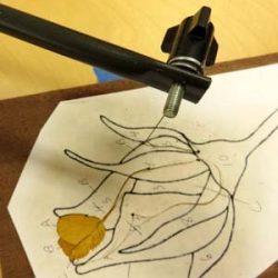 A manual scroll saw makes the first cuts in a simple rosebud design.
